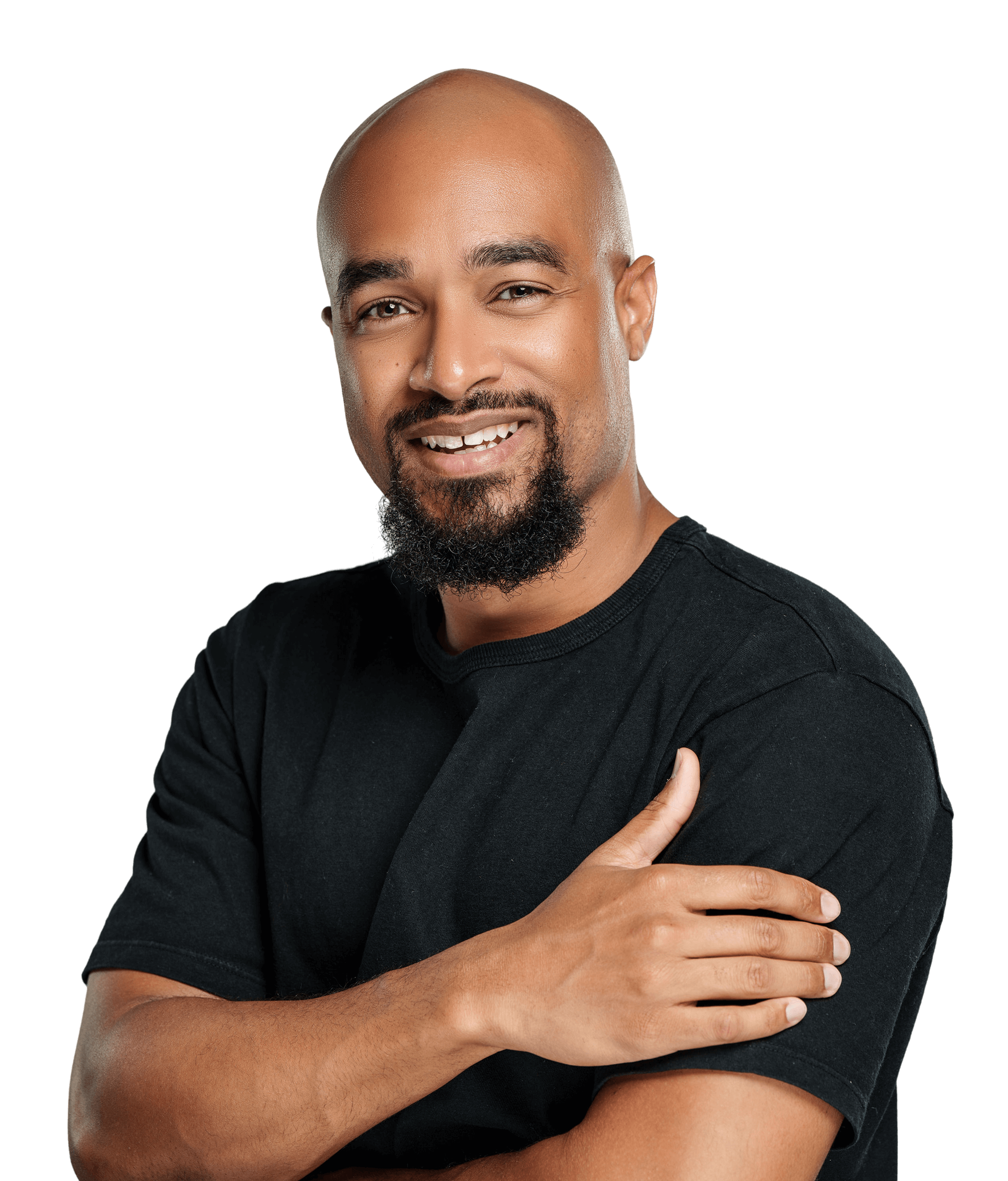 A man with a shaved head and a short beard, wearing a black t-shirt, stands with his arms crossed and smiles confidently at the camera against a plain background, embodying the look of someone who is financially free.